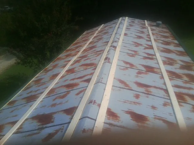 Rusted metal roof panels with new wood purlins before replacement — Storm Damage Roof Repair in North by Roofing Brothers