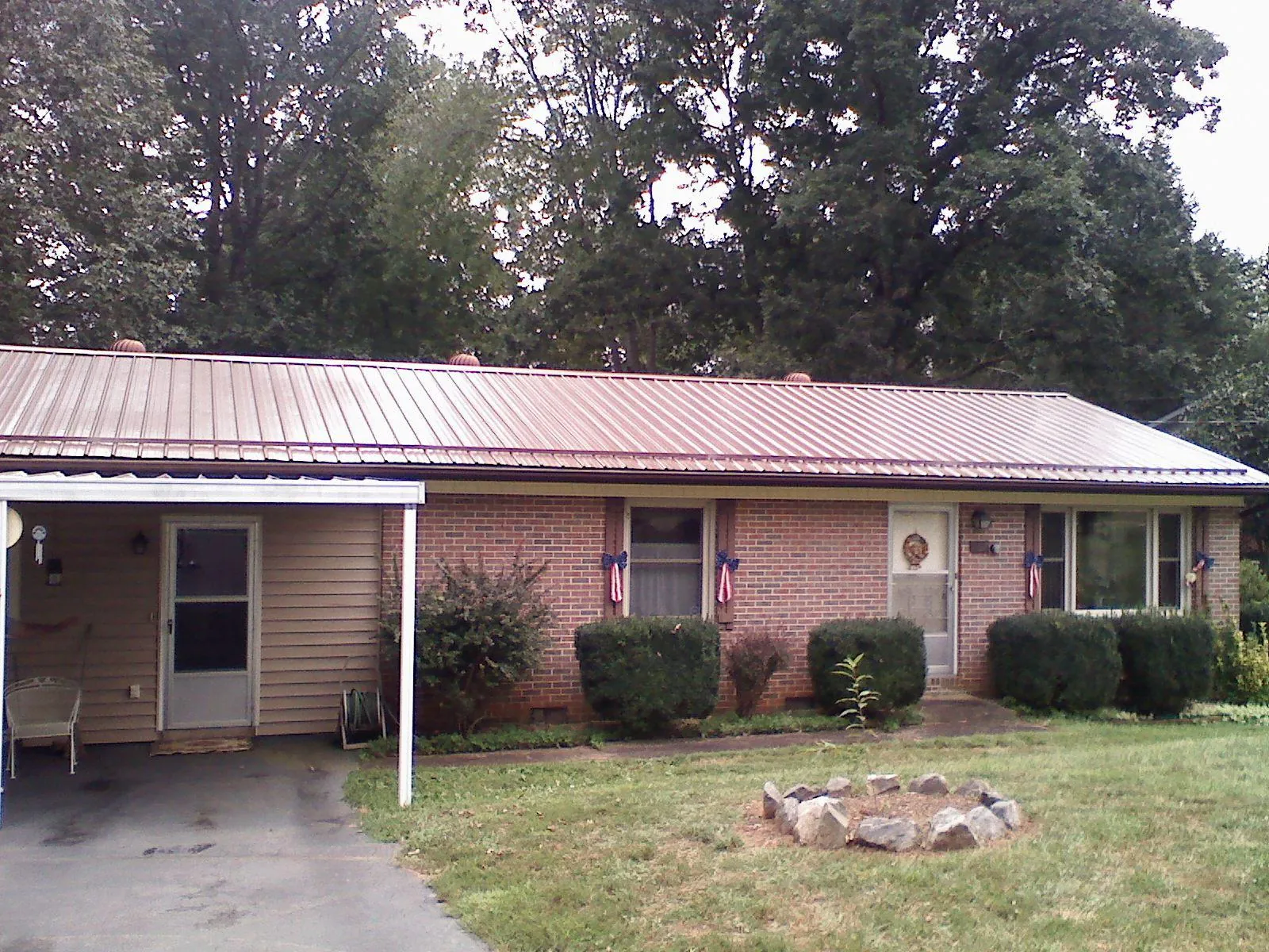 Bronze metal roof and carport on a brick ranch home — Roof Repair work by our crew in North